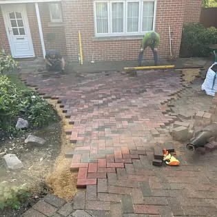 Block paving being laid on a driveway, herringbone pattern in progress