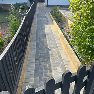 Finished block-paved pathway alongside a garden fence