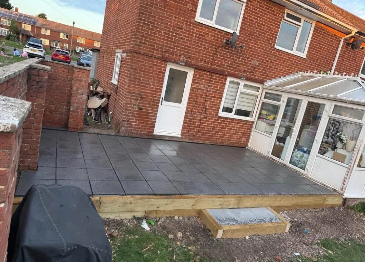 Newly laid charcoal-grey patio paving against a red-brick house extension in Southampton